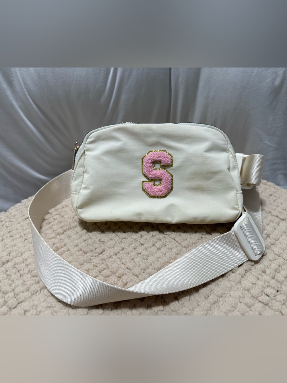 Cream Crossbody Bag with Pink 'S'.